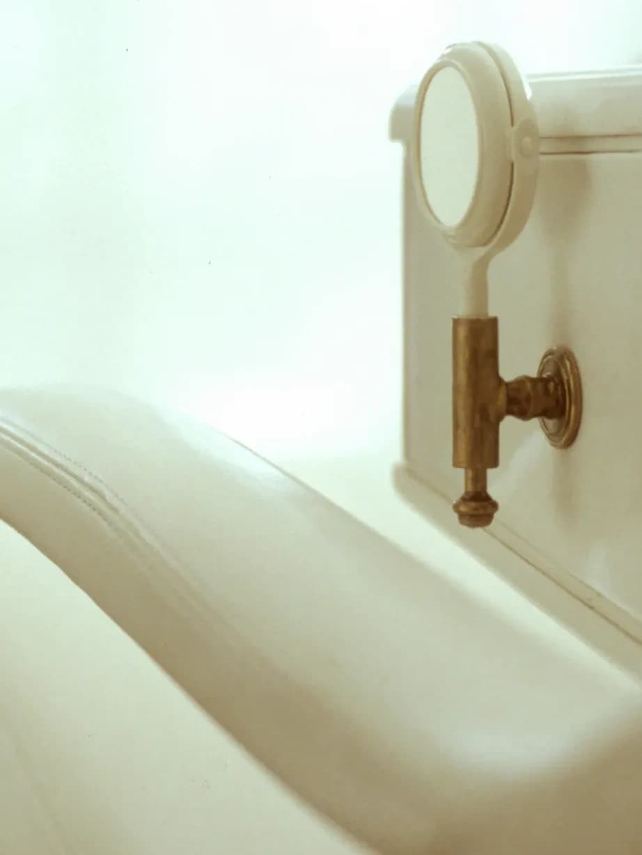 Detail of the treatment chair - cream leather stitching and a brass fixture