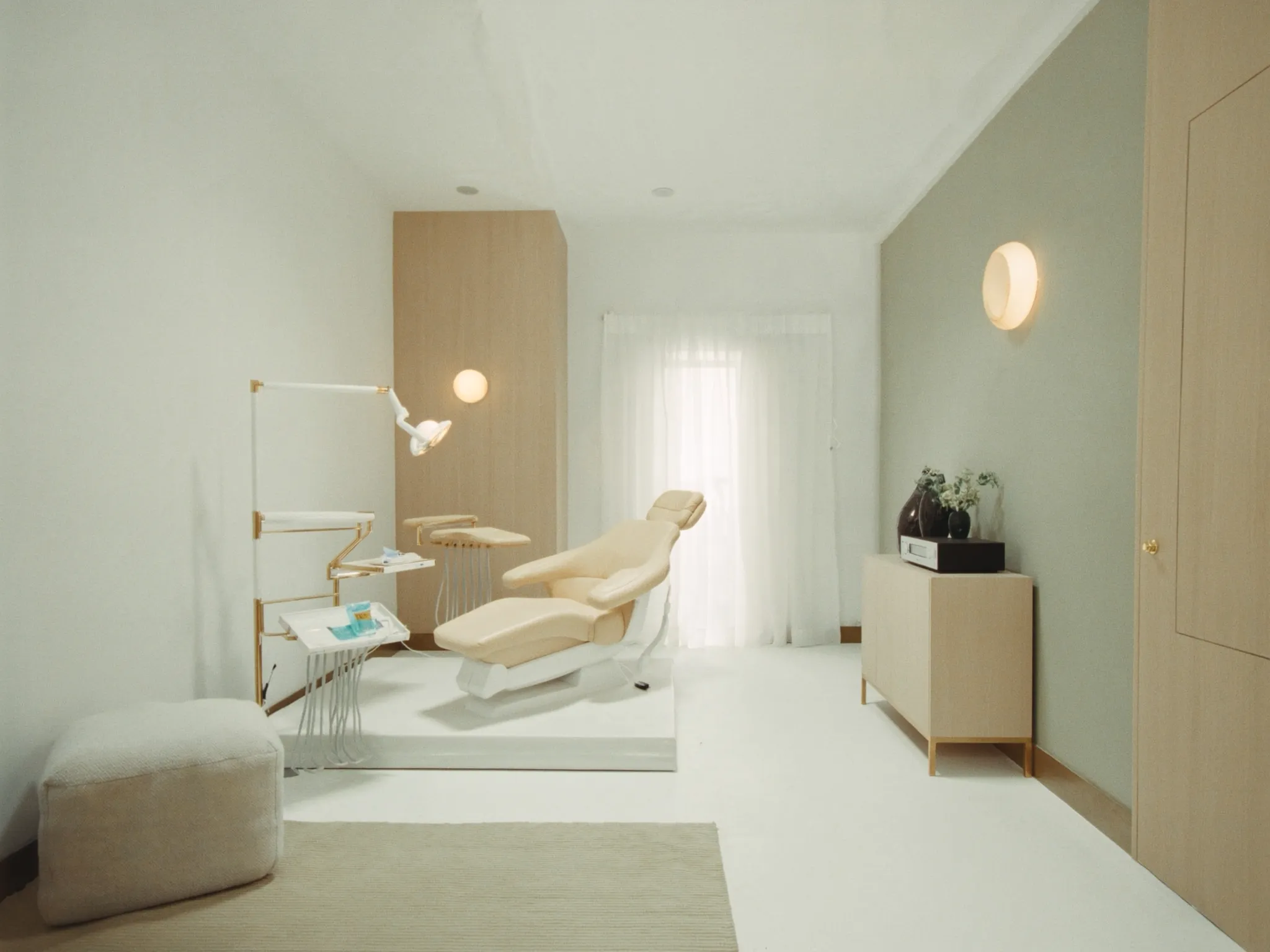 Treatment suite at Ngiti — cream leather chair, oak panels, and a sage accent wall